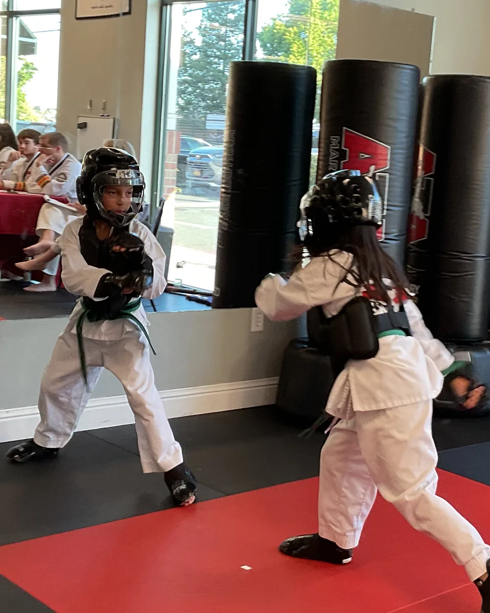 Two young students in headgear and chest guards facing off in a sparring stance at Element ATA Martial Arts in Martinez CA
